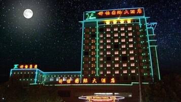 A multi-story hotel with illuminated signage and a prominent entrance.