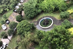 An aerial view of a parking lot with cars and a circular garden area surrounded by trees. - Wending Yaxuan Hotel (Zhengzhou)
