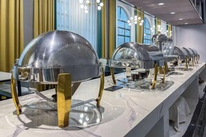 Un buffet composé de plusieurs présentoirs de nourriture, chacun étant surmonté d’un couvercle en forme de dôme et doté d’un socle de couleur dorée.