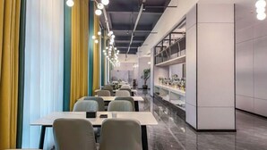 Un restaurante moderno con mesas y sillas largas, piso de mármol y una barra larga con estantes.