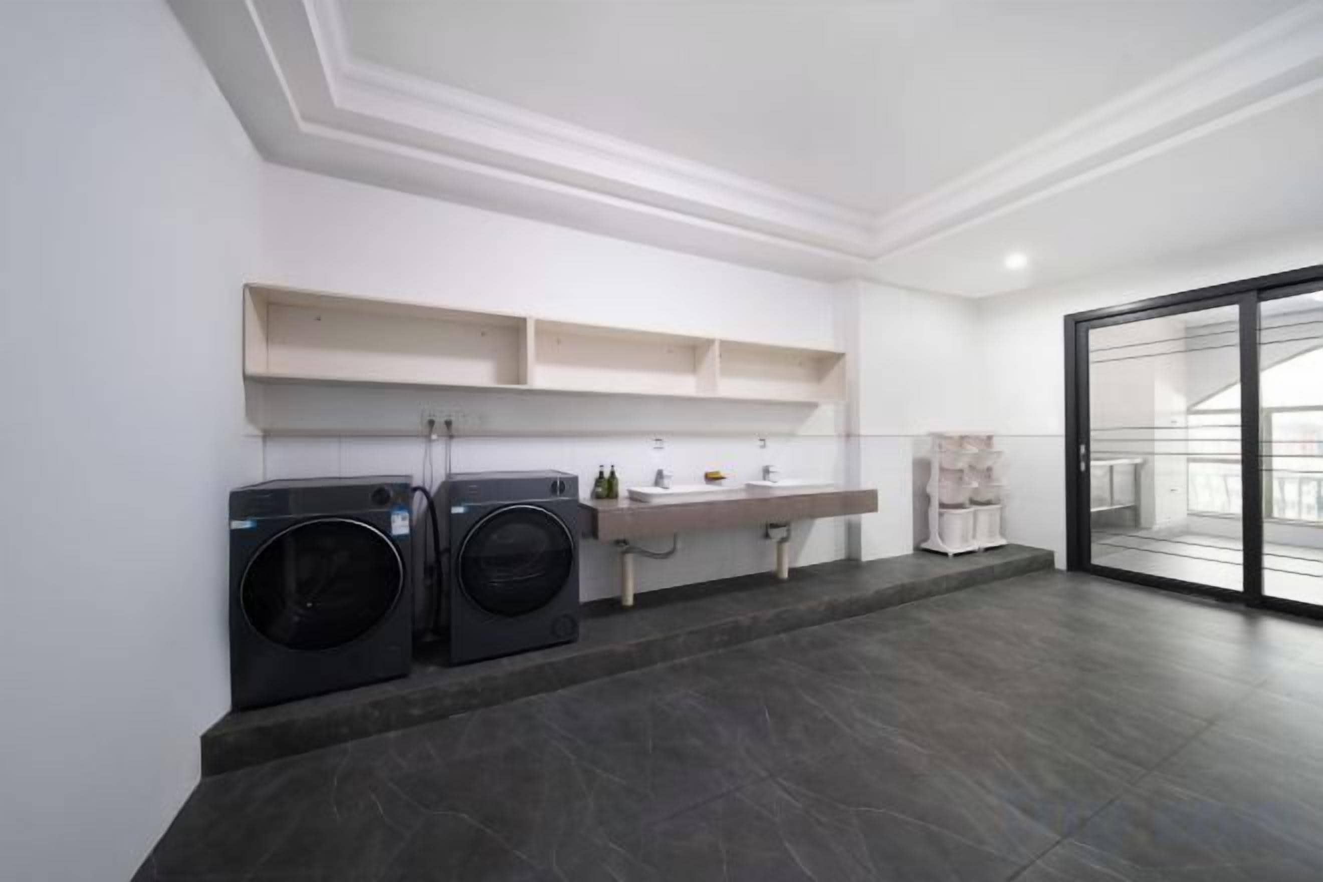 Un lavadero con dos lavadoras, un lavabo y un tendedero.