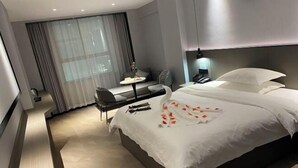 Una habitación de hotel moderna con una cama grande, un escritorio y una silla.