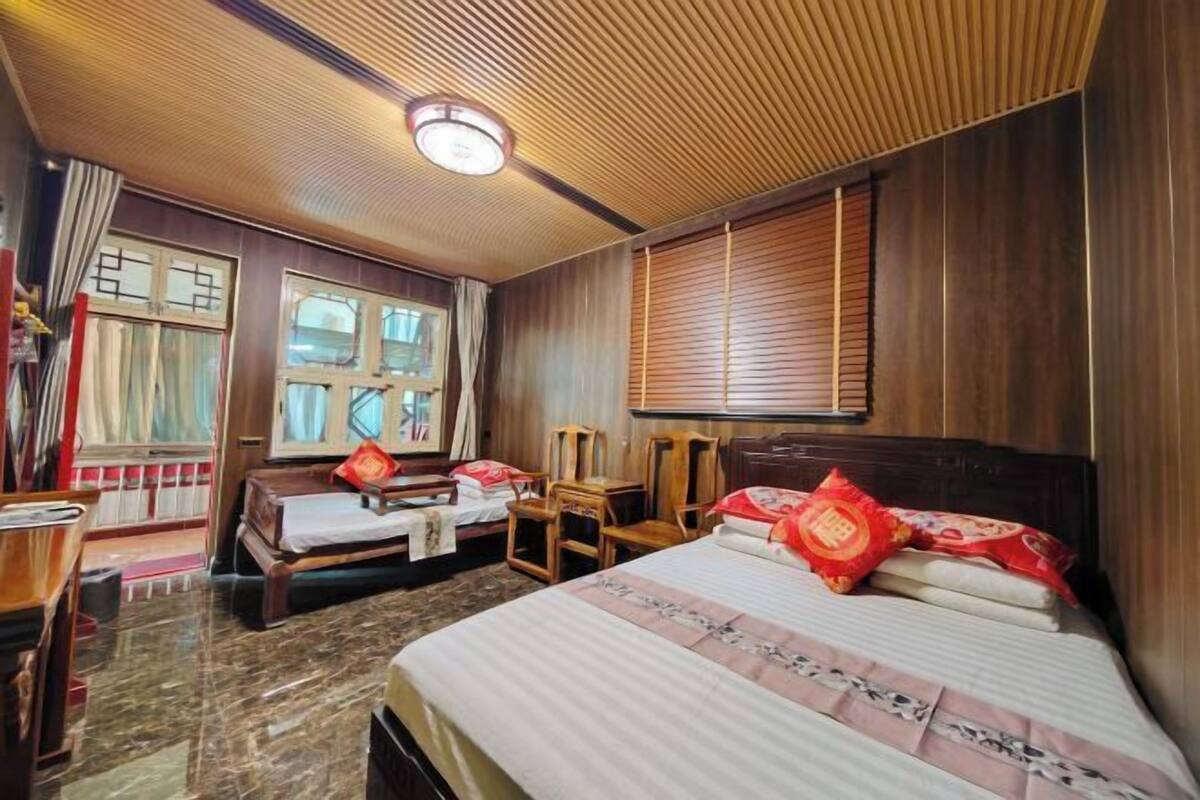 Una camera d'albergo con un letto, due comodini, una scrivania e una finestra con tende.