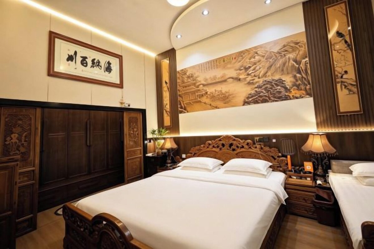 Una habitación tradicional con una cama grande, muebles de madera y obras de arte en las paredes.