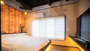 A modern bedroom with a bed, a large window, and an air conditioning unit. - Kyomachi Hoshizuki (Kyoto)