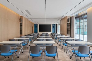 Un aula con filas de pupitres y sillas, una gran pizarra y una ventana que proporciona luz natural.