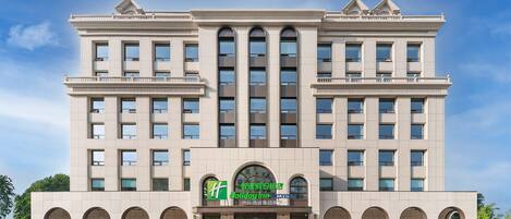 A large, multi-story hotel with a symmetrical facade, featuring a central entrance with a sign for Holiday Inn Express.