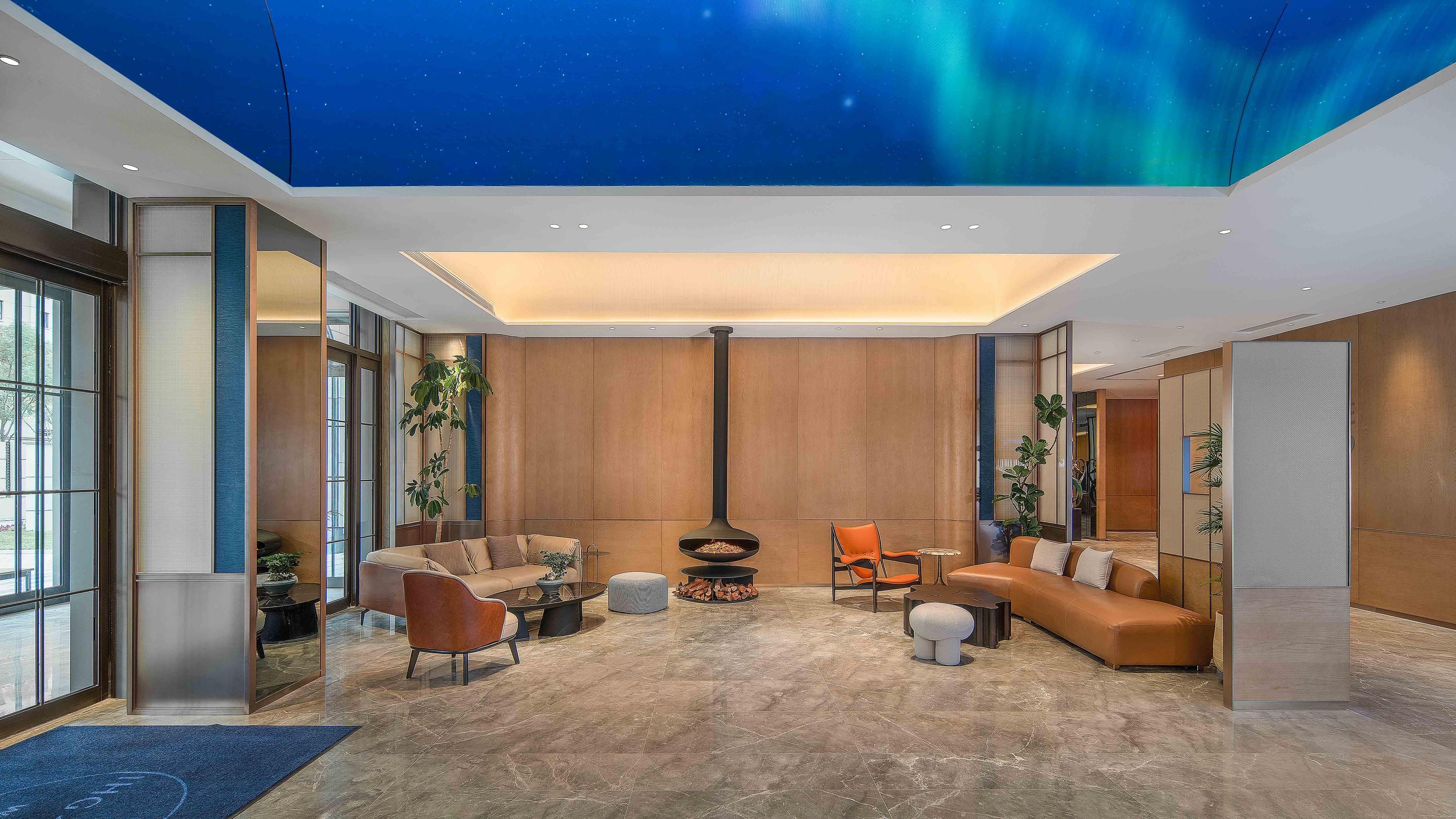 Una sala de estar moderna con chimenea, asientos cómodos y ventanas amplias.