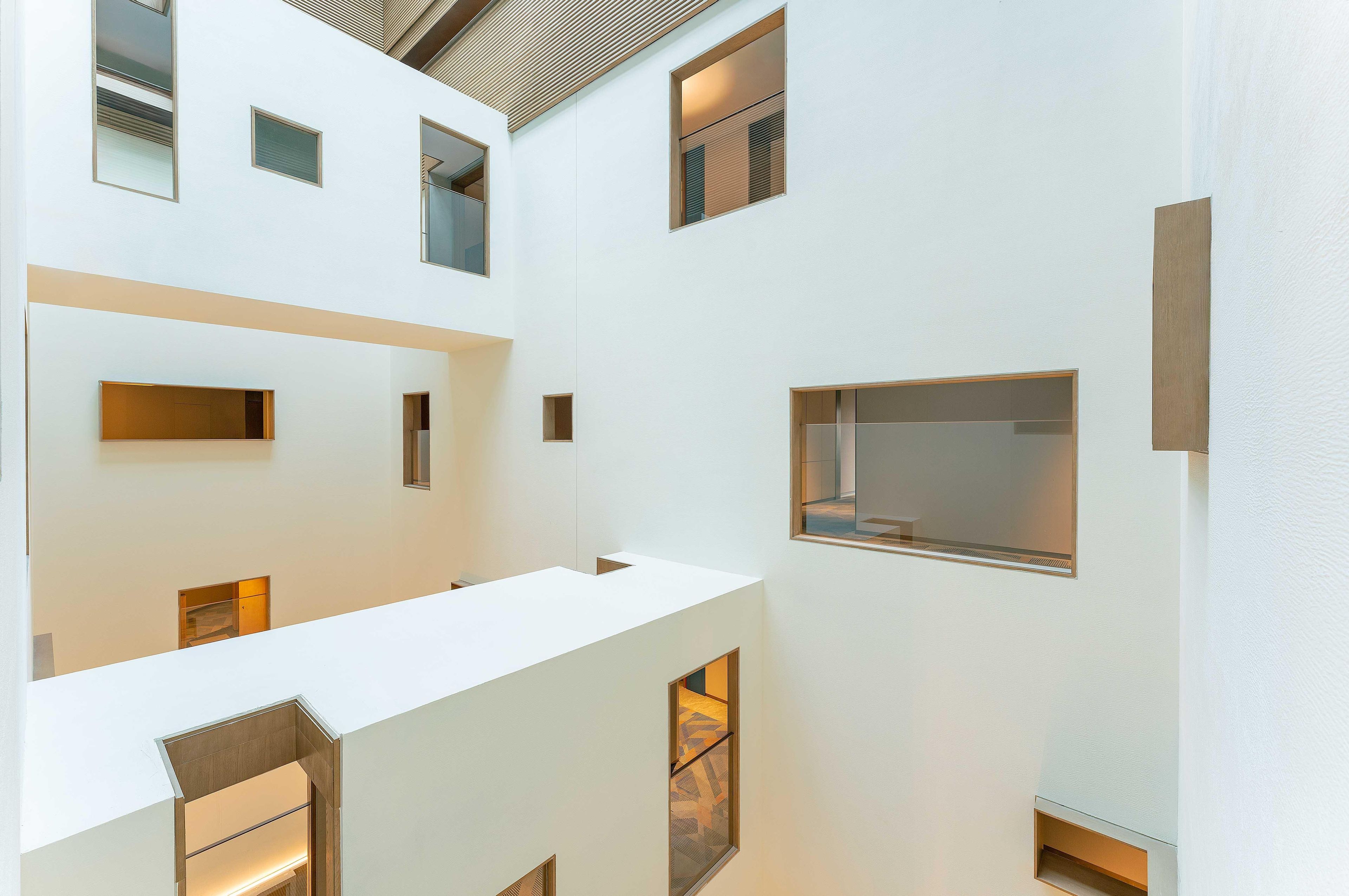 A modern interior with multiple levels, large windows, and a minimalist design.