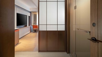 Un interior moderno con una puerta corredera que da a un comedor, un televisor de pantalla plana y suelo de madera.
