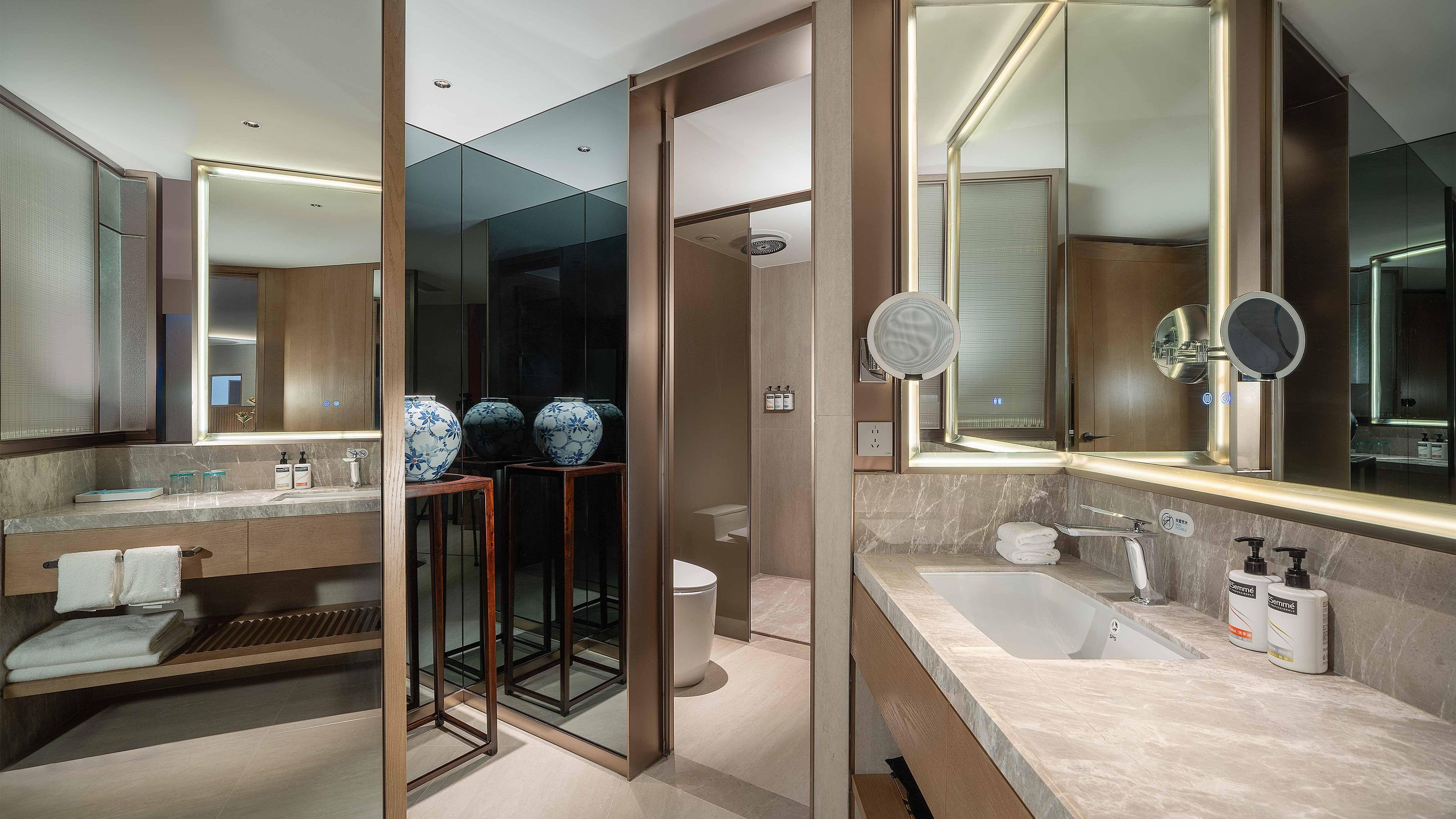 A modern bathroom with a large mirror, a bathtub, and a shower area.