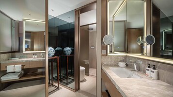 Un baño moderno con un espejo grande, una bañera y una zona de ducha.