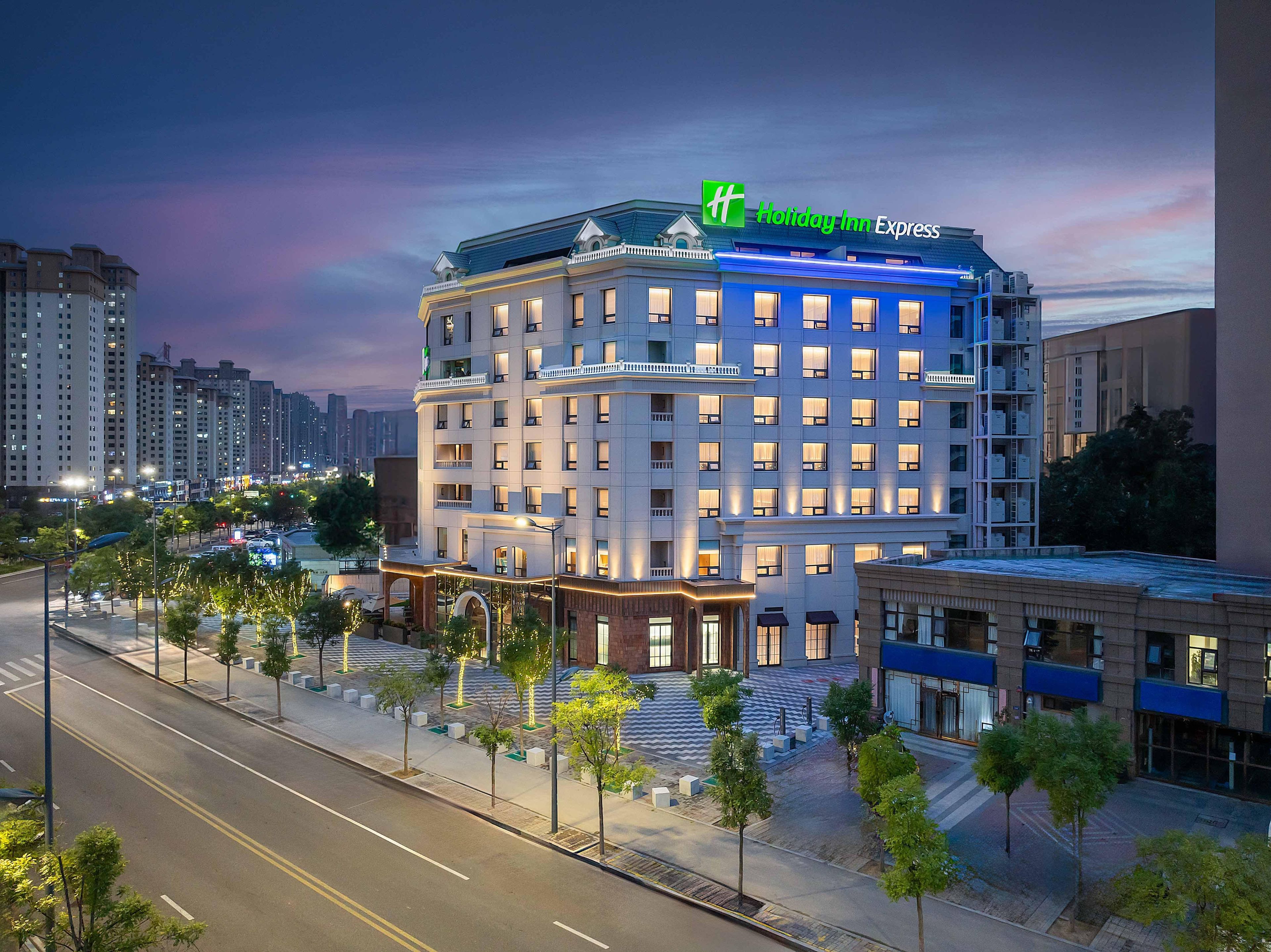 A Holiday Inn Express hotel with a modern design, multiple floors, and a prominent green logo.