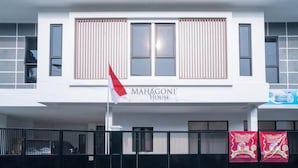 A building with a sign reading "MAHAGONI HOUSE". - Hotel O Mahagoni House Syariah (Bogor)