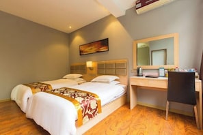 A hotel room with two beds, a desk, a chair, a mirror, and a painting on the wall.