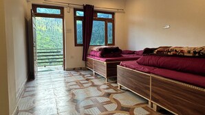 Ein Schlafzimmer mit einem Bett, Deckenventilator, einem Vorhangfenster und einem gemusterten Boden.