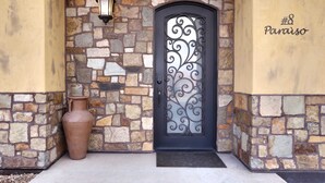 A stone facade with a black door featuring decorative metalwork, a potted plant, and a sign reading "#8 Paraiso". - Luxury Downtown Rental (Hot Tub/Pet Friendly) #8 (Moab)