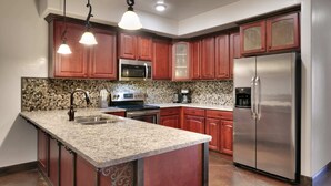 A kitchen with granite countertops, stainless steel appliances, and wooden cabinets. - Luxury Downtown Rental (Hot Tub/Pet Friendly) #8 (Moab)