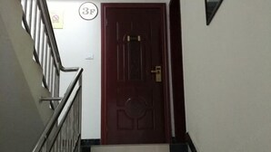 A staircase leading to a door with a number plate. - Mingxin Hotel (Enshi City)