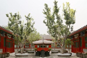 A courtyard with traditional architecture, potted plants, and a central seating area. - Ancient City Old Courtyard Boutique Hotel (Beijing)