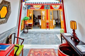 A traditional interior with a dining area, a reception desk, and a view of the entrance. - Ancient City Old Courtyard Boutique Hotel (Beijing)