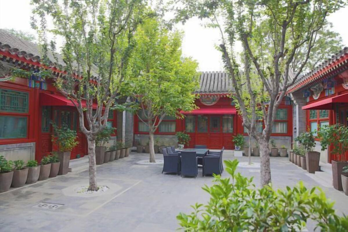 A courtyard with traditional architecture, potted plants, and outdoor seating.