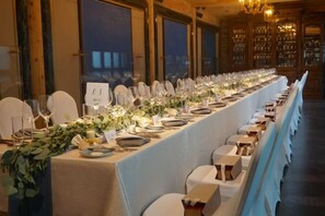 A long dining table set with chairs, glassware, and plates, indicating a formal dining setup. - Ancient City Old Courtyard Boutique Hotel (Beijing)