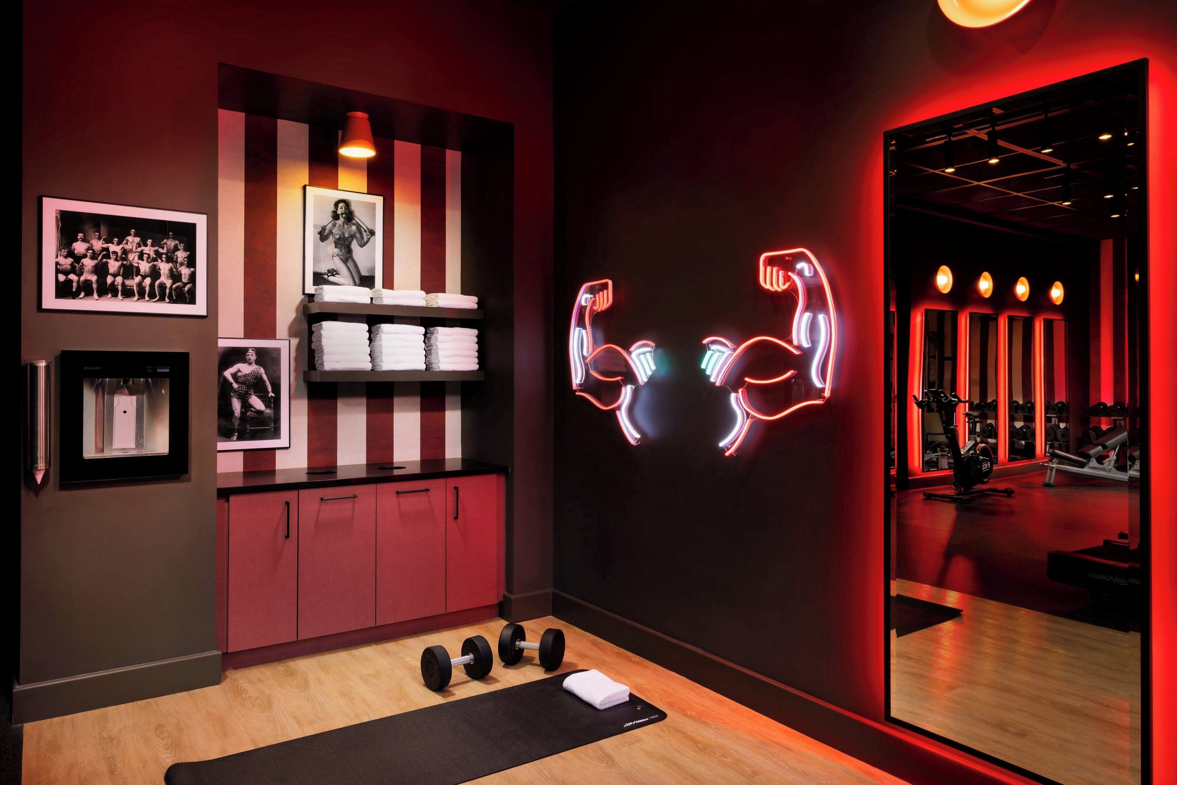 A gym with exercise equipment, a mirror, and motivational wall art.