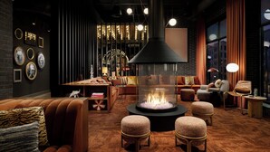 Eine moderne Lounge mit Kamin, bequemen Sitzgelegenheiten und Blick auf die Stadt.