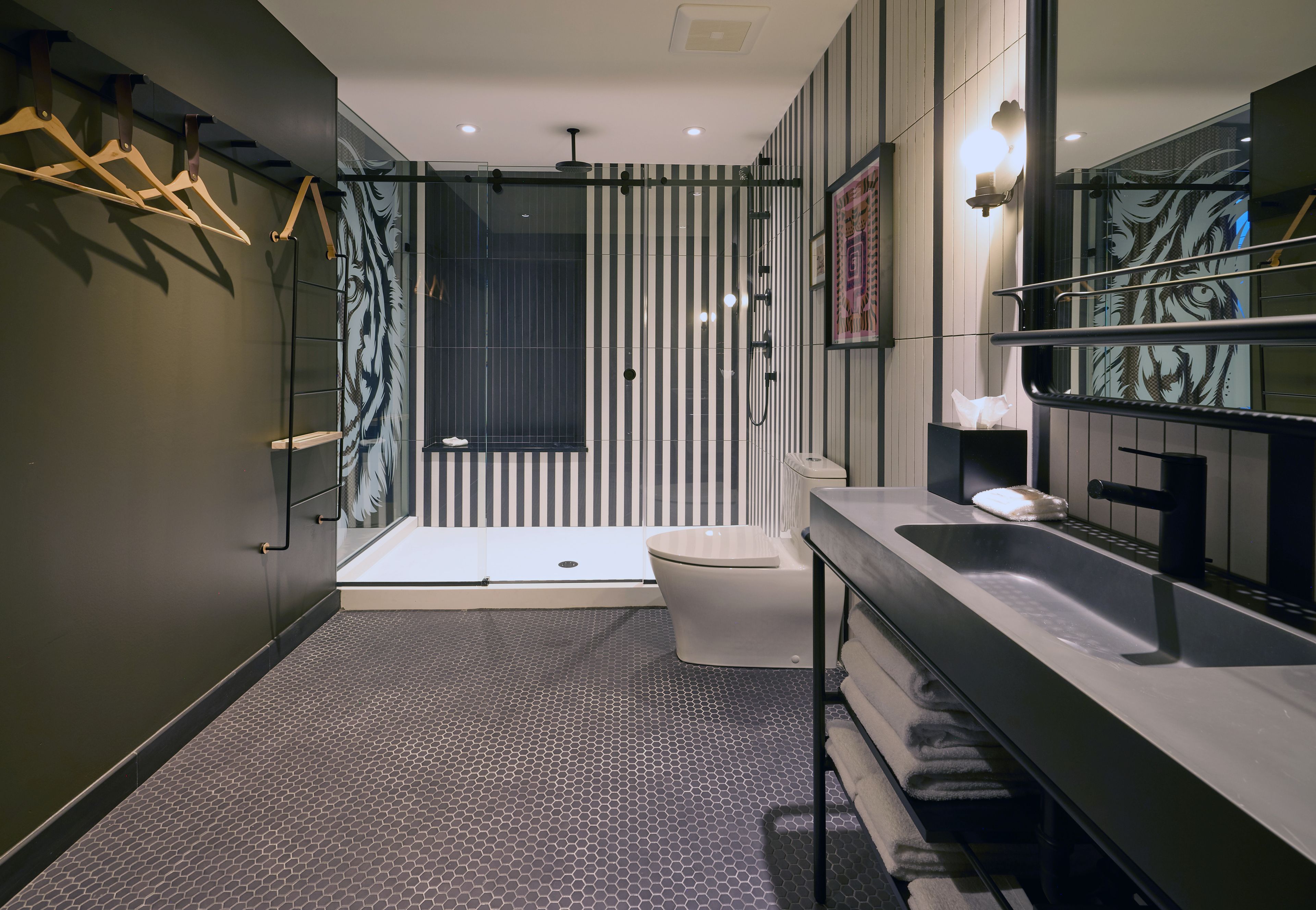 Un baño moderno con cabina de ducha de vidrio, inodoro blanco y tocador con espejo.