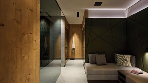 Ein modernes Interieur mit einer Wand aus Holzvertäfelung, einer Couch mit Kissen und einem kleinen Tisch mit einem Buch.