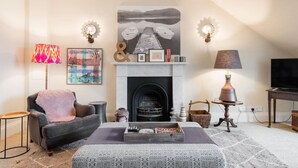 A cozy living room with a fireplace, a sofa, a coffee table, and a television.