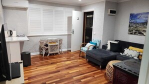 A compact living space with a sofa, a small table, and a chair. - 2BDR Holiday Flat near Bright-Entire Place (Freeburgh)