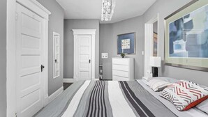 Una camera da letto con un letto, una cassettiera, uno specchio e un lampadario.