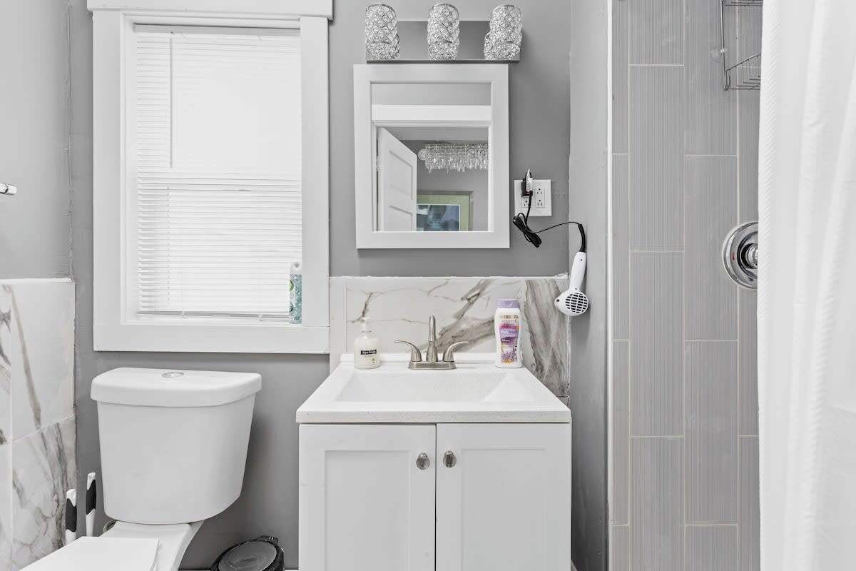 Ein Badezimmer mit Toilette, Waschbecken, Spiegel und Dusche.