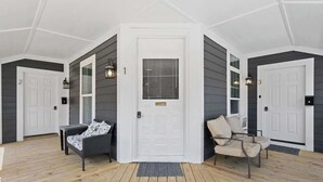 A spacious porch with a white door, two chairs, and a small table. - New Castle Getaway | Fireplace • Prime Location (New Castle)