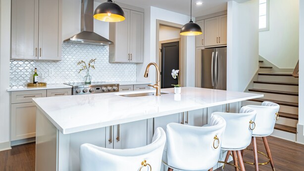 A modern kitchen with a central island, stainless steel appliances, and pendant lighting.