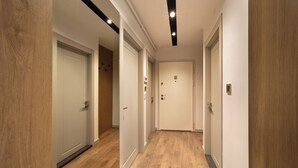 A hallway with wooden flooring and white doors, featuring recessed lighting and a modern ceiling design. - Marmada Suites (Istanbul)
