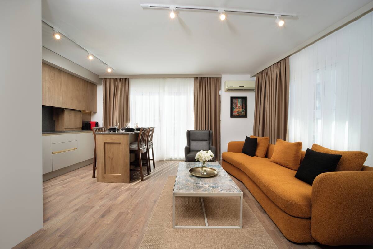 A modern living room with a sofa, coffee table, and dining area.