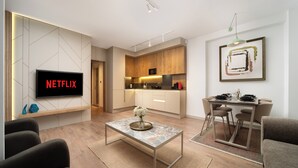 A modern living room with a flat-screen TV, a coffee table, and seating. - Marmada Suites (Istanbul)