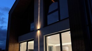 Een modern gebouw met grote ramen en een houten gevel.