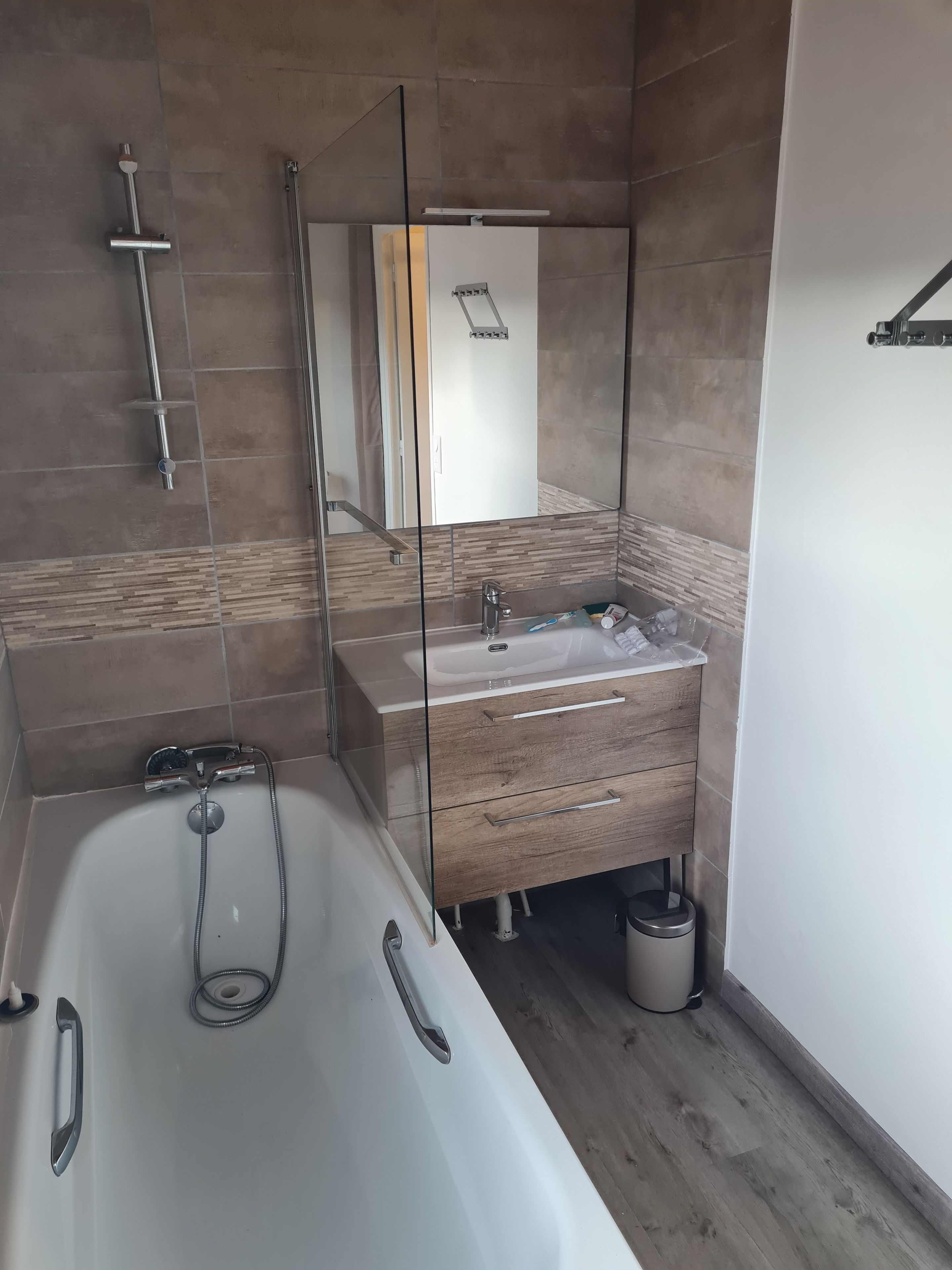 Une salle de bain moderne avec une baignoire, un meuble-lavabo avec un espace vitré et une zone de douche.