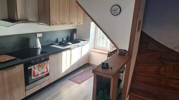Eine moderne Küche mit Holzausstattung, einer schwarzen Arbeitsplatte und einem eingebauten Backofen.