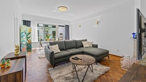 A modern living room with a sectional sofa, a round coffee table, and a fireplace. - Central & luminous apartment in Antwerp, foreseen with all comforts (Antwerpen)