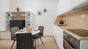 A compact kitchen with a dining area, featuring a built-in oven, a sink, and a small coffee maker. - Awesome apartment in Podstrana with WiFi (Podstrana)