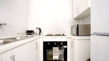 Una cocina compacta con horno integrado, microondas y lavavajillas.
