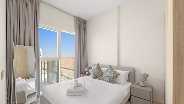 Een moderne hotelkamer met een groot bed, een nachtkastje en uitzicht op de omgeving.