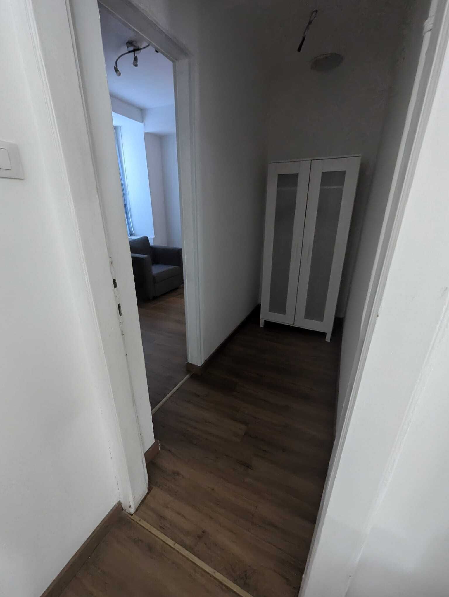 Ein Korridor mit Holzdielen und weißen Wänden.
