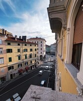 Veduta di una strada con edifici, un attraversamento pedonale e veicoli.