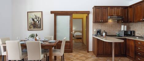Una cocina moderna con armarios de madera, un comedor con mesa para cuatro y una isla de cocina.
